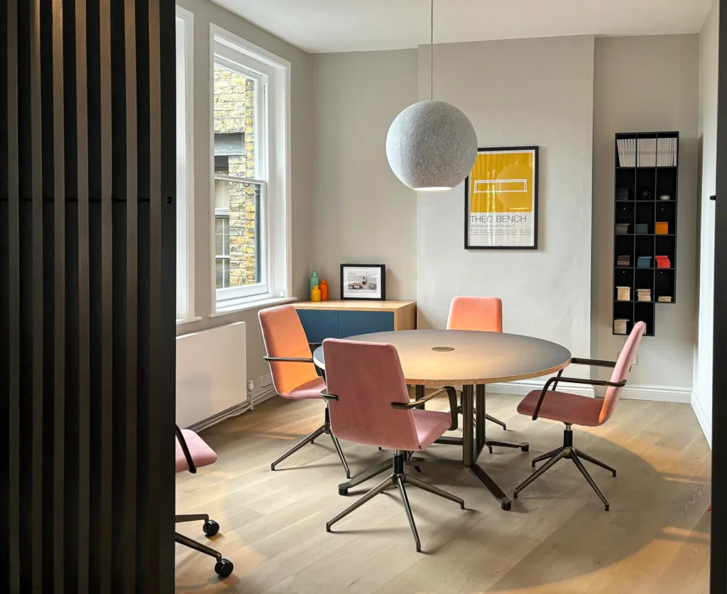 Round y based table with pink boardroom chairs